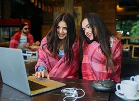 duas garotas assistindo algo no laptop foto