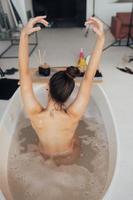 bela jovem tomando banho em casa vista traseira foto