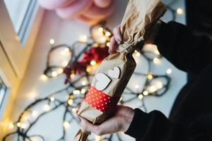 menina segurando um presente de natal na mão foto