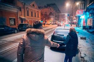 casal adulto jovem andando na calçada coberta de neve foto