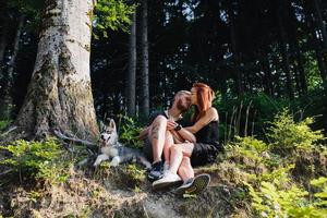 lindo casal sentado em uma floresta perto da árvore foto