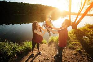 jovem família com uma criança na natureza foto