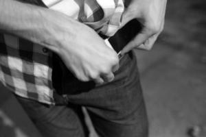 um homem ajusta seu cinto sobre fundo de jeans foto