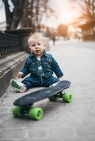 menino engraçado com skate na rua foto