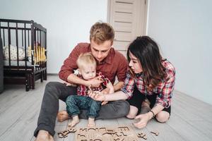 família feliz está jogando juntos no chão foto