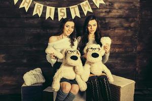 duas garotas encantadoras brincando com brinquedos de natal foto