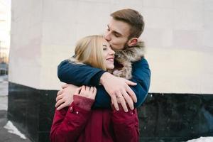 jovem sorridente feliz casal europeu abraçando no inverno foto