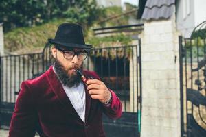 um homem rico com barba fuma berço foto