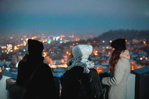 amigos em um fundo da paisagem urbana à noite foto