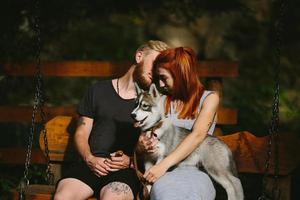 lindo casal junto com cachorro em um balanço foto