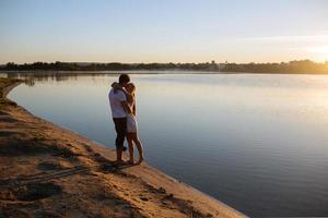 casal ao nascer do sol na praia foto