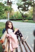 menina com um smartphone sentado em um banco foto