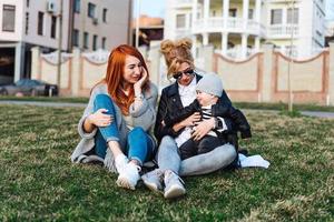 mãe e tia brincam com um menino no parque foto