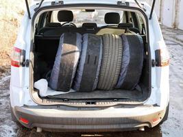 conjunto de pneus de verão no porta-malas do carro foto