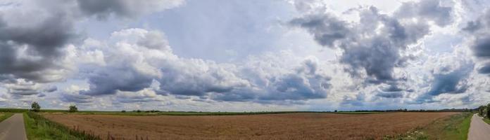 panorama de nuvens deslumbrantes no céu acima de um campo agrícola. foto