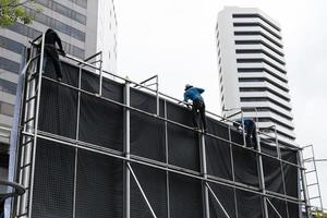 trabalhadores escalam estruturas de outdoors para instalar outdoors foto