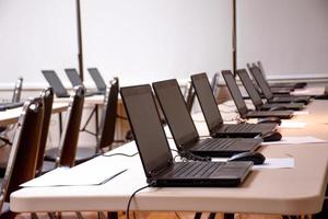 laptop organizando linhas na mesa na sala de seminários foto