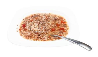 sopa de trigo sarraceno em chapa branca com colher isolada foto
