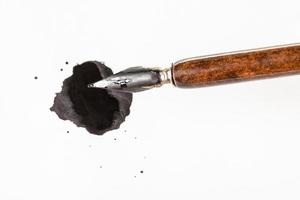 vista superior da caneta de ponta marrom sobre borrão de tinta preta foto