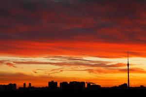 panorama urbano com dramático nascer do sol vermelho escuro foto