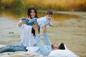 família jovem feliz relaxando juntos no lago foto