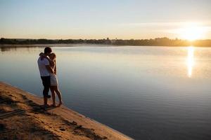 casal ao nascer do sol na praia foto