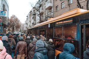 muitas pessoas não identificadas estão esperando o transporte da cidade no ponto de ônibus foto