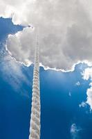 corda bamba sobe para nuvens no céu escuro foto