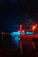 cidade à noite à beira do lago. aterro. foto