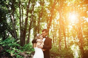 lindo casal de noivos posando na floresta foto