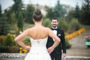 lindo casal de noivos em pé um em frente ao outro foto