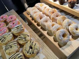 linhas de rosquinhas deliciosas frescas na padaria, rosquinhas múltiplas saborosas, rosquinhas de foco seletivo foto