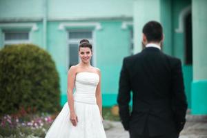 lindo casal de noivos em pé um em frente ao outro foto