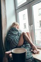 menina sentada em uma janela em um cobertor foto