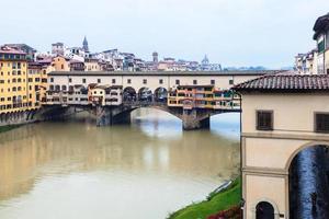 ponte vecchio e arno em florença na chuva de outono foto