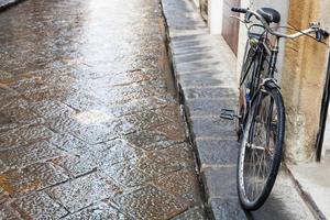 bicicleta na rua molhada na cidade de florença na chuva foto