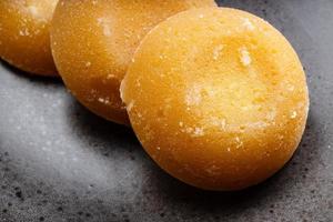 pedaços redondos inteiros de açúcar de palma close-up em preto foto