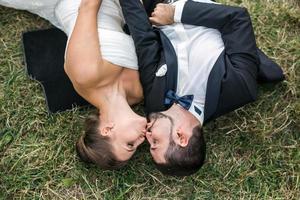 casal de noivos deitado na grama foto