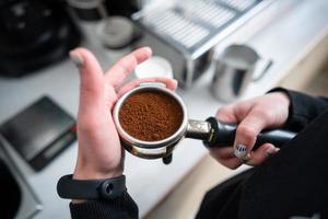 barista segurando porta-filtro com café moído foto