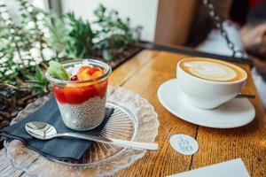 cappuccino com colher na xícara e sobremesa foto