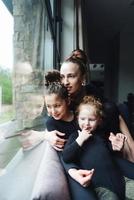 mãe e duas filhas juntas na janela foto