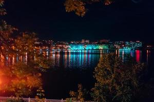 cidade à noite à beira do lago. foto