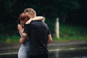 lindo casal abraçando na chuva foto