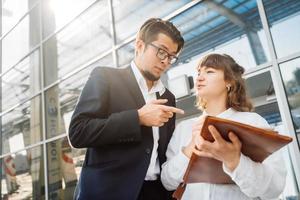 empresário e empresária olham para papéis importantes foto