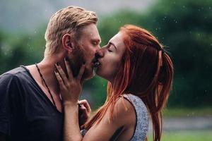 lindo casal beijando na chuva foto