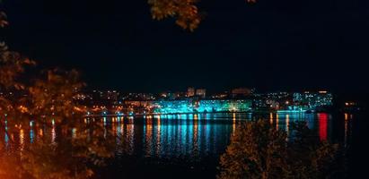 cidade à noite à beira do lago. foto