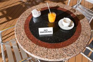 suco de laranja fresco e cappuccino na mesa de não fumar foto