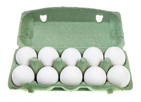 dez ovos de galinha branca em recipiente verde isolado foto