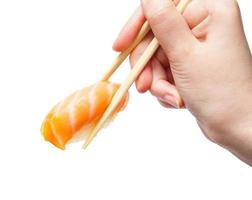 pauzinhos seguram saquê nigiri sush com salmão foto