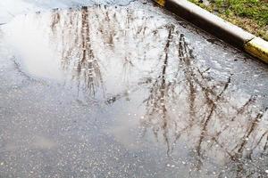 gotas de chuva na poça na rua urbana foto